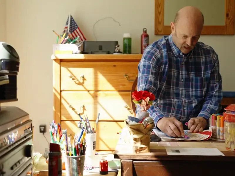 Resident coloring in his room with light shining in window