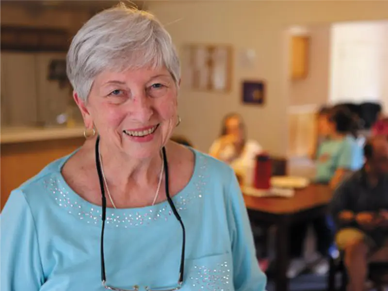 Good Neighbor Village community event with staff giving resident a hug