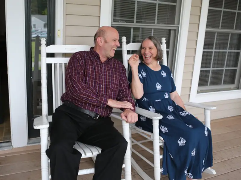 two Good Neighbor Village residents enjoying each others company on the cottage porch